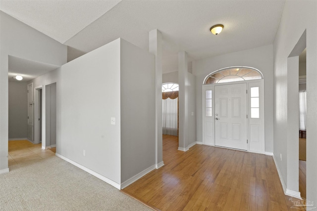 foyer entrance featuring a textured ceiling and light hardwood / wood-style flooring