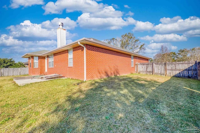 view of side of home featuring a patio area and a yard