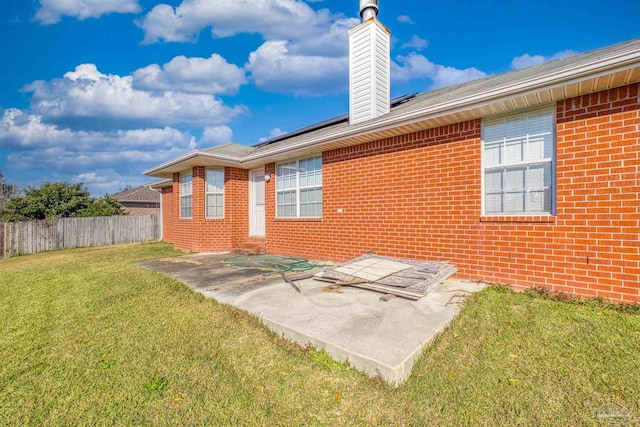 rear view of house featuring a patio and a lawn