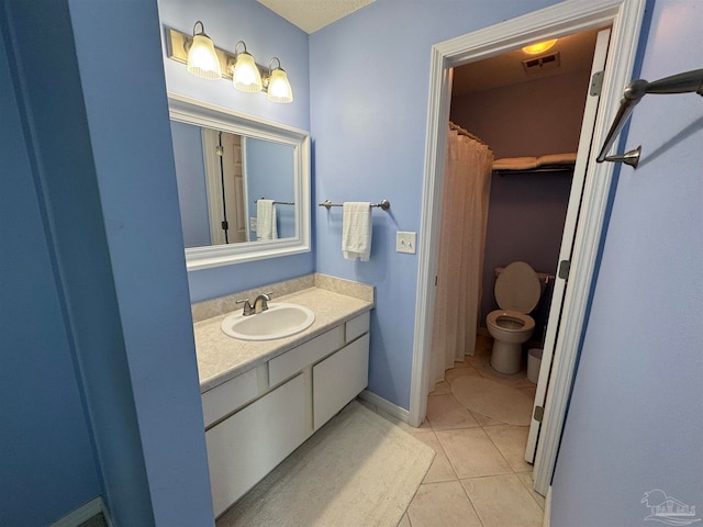 bathroom featuring toilet, vanity, and tile patterned floors