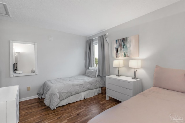 bedroom with dark wood-type flooring and a textured ceiling