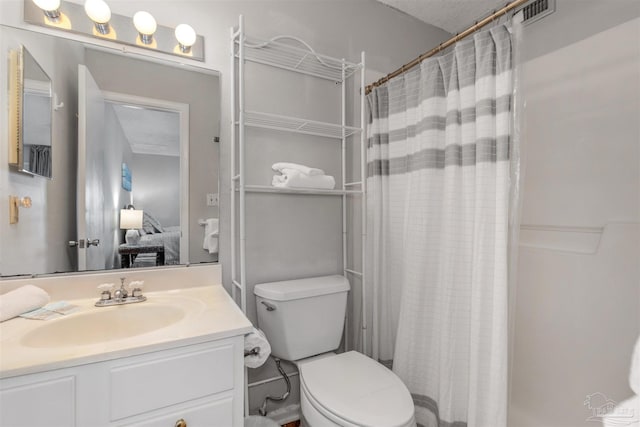 bathroom featuring walk in shower, vanity, and toilet