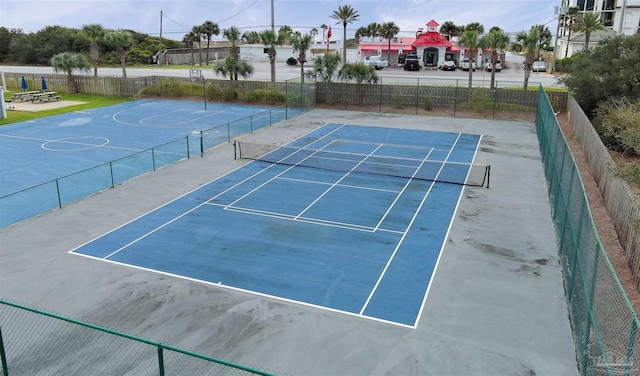 view of tennis court featuring basketball hoop