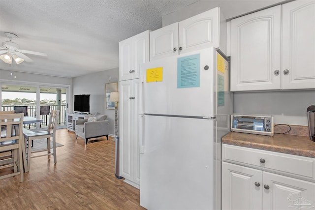 kitchen featuring white refrigerator, hardwood / wood-style floors, white cabinets, and ceiling fan