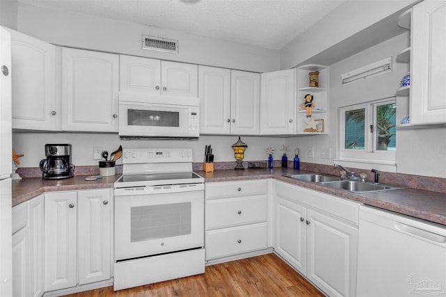 kitchen featuring sink, white appliances, a textured ceiling, and white cabinets