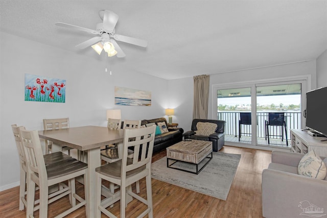 dining space with light hardwood / wood-style flooring and ceiling fan