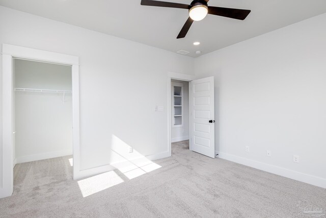 unfurnished bedroom featuring light carpet, a closet, and ceiling fan