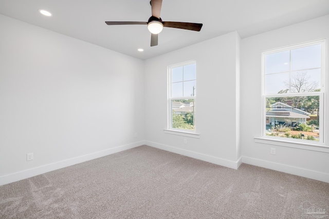 unfurnished room featuring light carpet, ceiling fan, and a healthy amount of sunlight