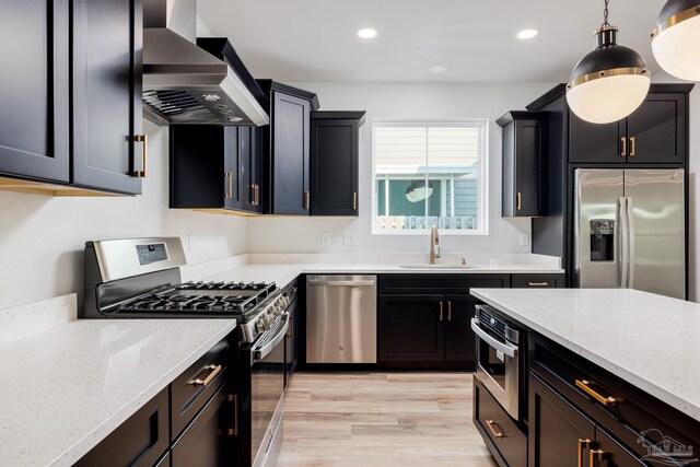 kitchen featuring light hardwood / wood-style flooring, stainless steel appliances, wall chimney range hood, sink, and light stone counters