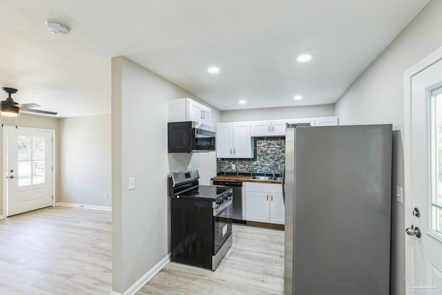 kitchen featuring white cabinetry, wooden counters, backsplash, appliances with stainless steel finishes, and light wood-type flooring