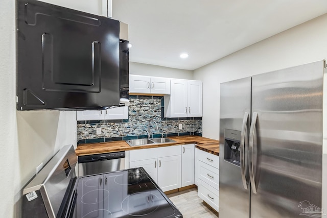 kitchen with white cabinetry, sink, stainless steel appliances, tasteful backsplash, and wooden counters