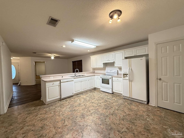 kitchen with white cabinetry, sink, kitchen peninsula, a textured ceiling, and white appliances