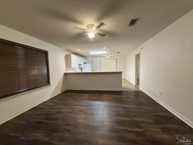 empty room featuring ceiling fan, dark hardwood / wood-style flooring, and a textured ceiling