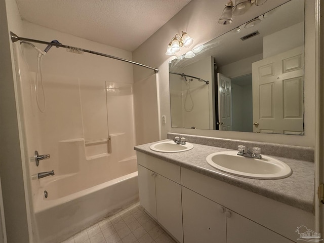 bathroom featuring tile patterned floors, vanity, shower / tub combination, and a textured ceiling