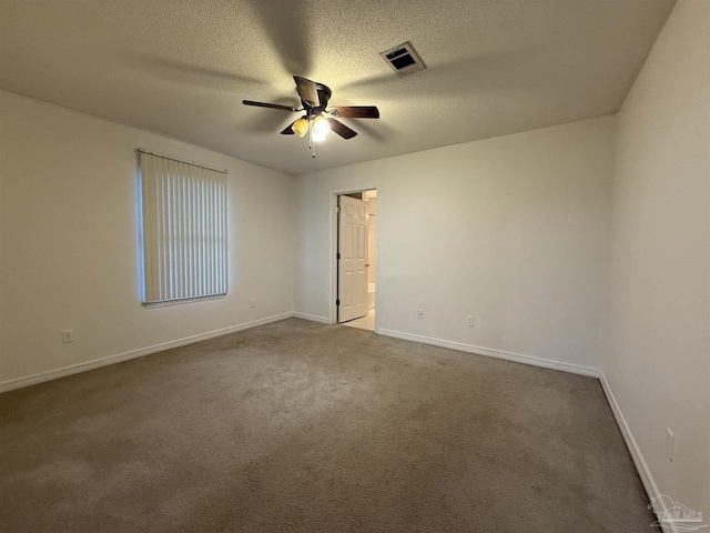 empty room featuring ceiling fan, carpet floors, and a textured ceiling