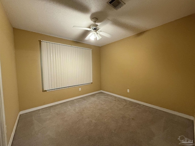 carpeted empty room with ceiling fan and a textured ceiling