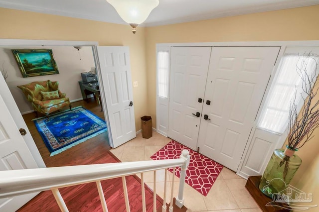 foyer entrance featuring light tile patterned flooring and baseboards