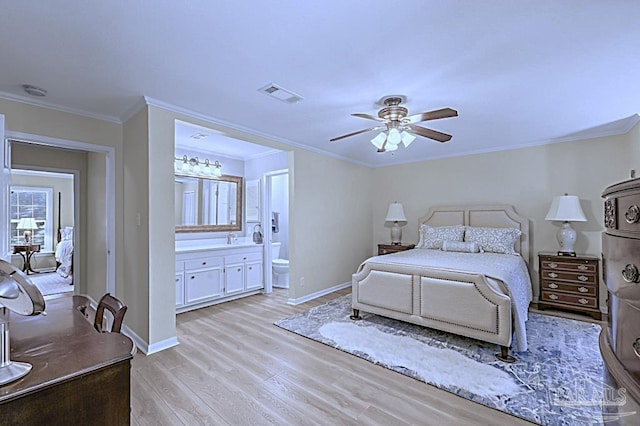 bedroom featuring visible vents, light wood-style flooring, ornamental molding, connected bathroom, and baseboards