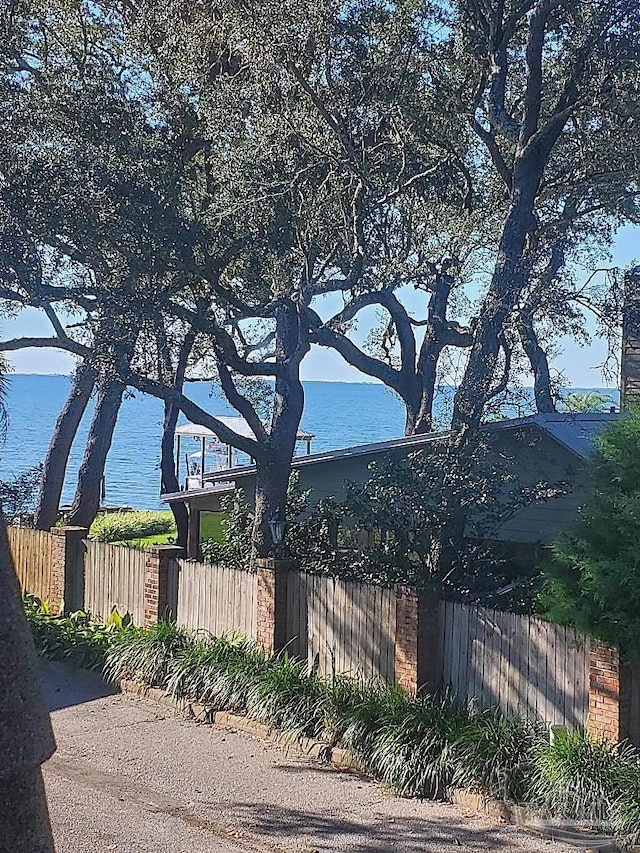 view of property exterior featuring a water view and fence