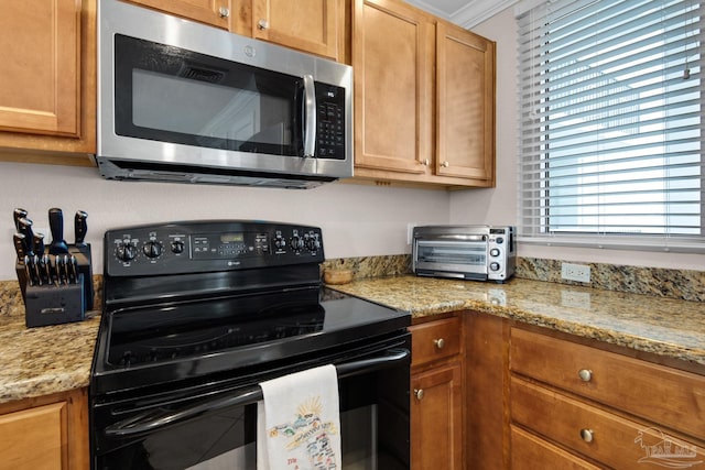 kitchen featuring light stone counters and black electric range oven