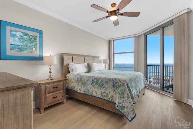 bedroom featuring a wall of windows, ornamental molding, access to exterior, a water view, and light wood-type flooring