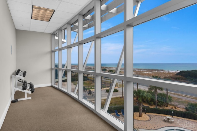 sunroom / solarium with a water view and a paneled ceiling