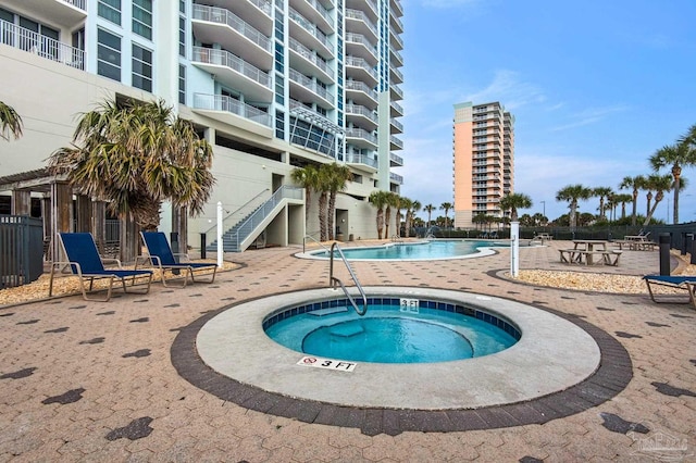 view of swimming pool featuring a hot tub