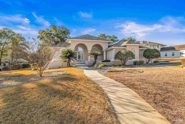 mediterranean / spanish home featuring a front yard