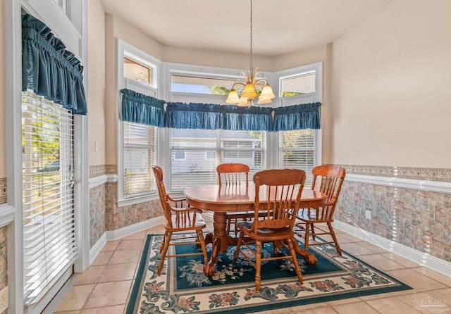 dining room with a healthy amount of sunlight, light tile patterned floors, and an inviting chandelier