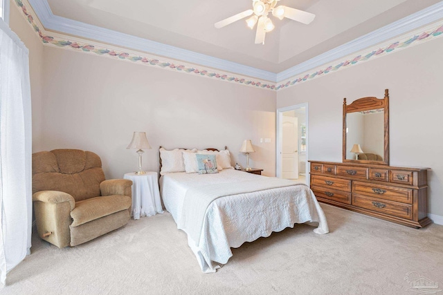 bedroom featuring ornamental molding, carpet floors, ceiling fan, and a tray ceiling