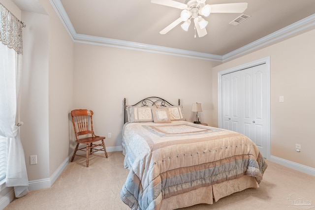 carpeted bedroom featuring crown molding, a closet, and ceiling fan