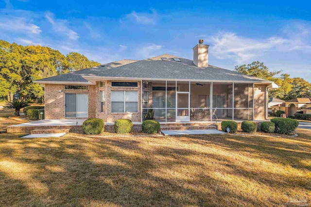 rear view of property with a patio, a sunroom, and a lawn