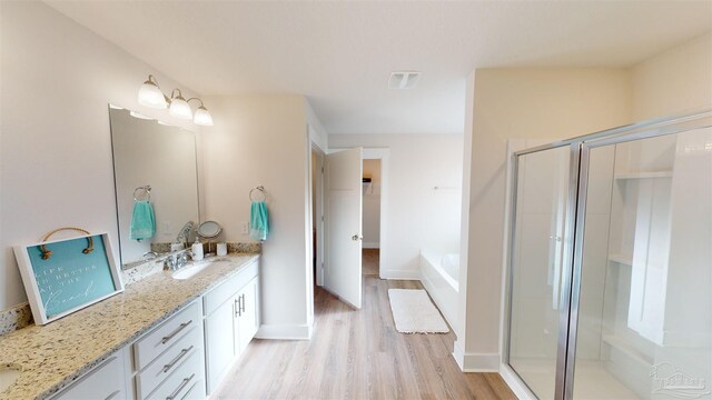 bathroom featuring hardwood / wood-style floors, vanity, and separate shower and tub