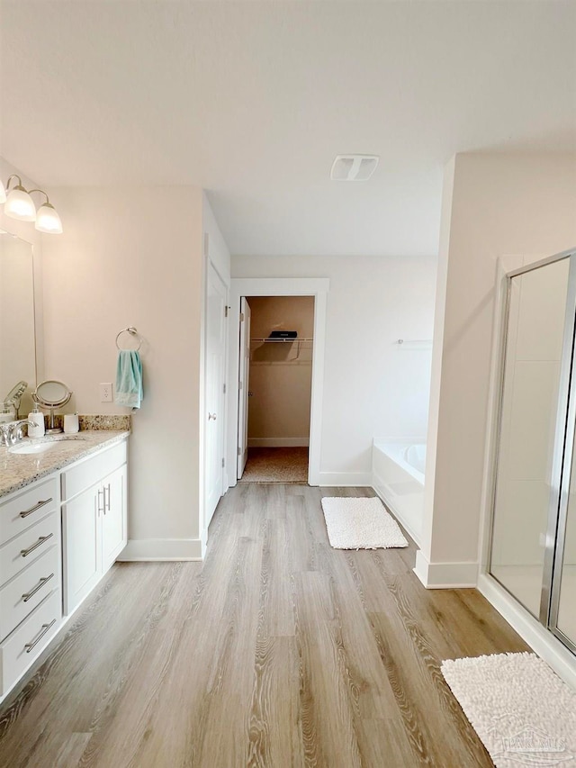 bathroom with shower with separate bathtub, vanity, and hardwood / wood-style flooring