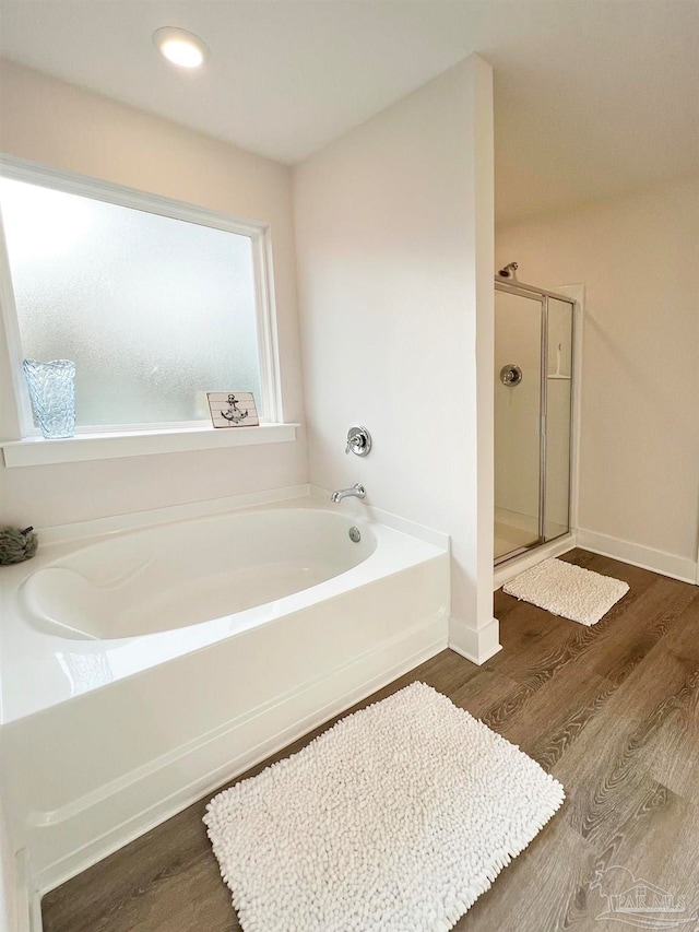 bathroom with shower with separate bathtub and hardwood / wood-style floors