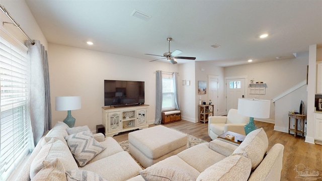 living room featuring light wood-type flooring and ceiling fan