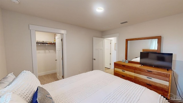 carpeted bedroom with a closet and a walk in closet