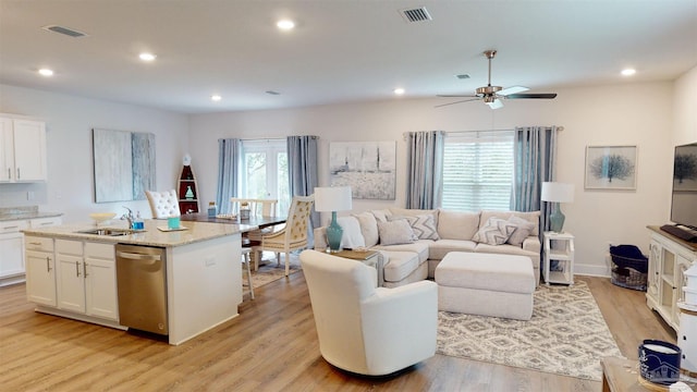 living room with ceiling fan, sink, and light hardwood / wood-style floors