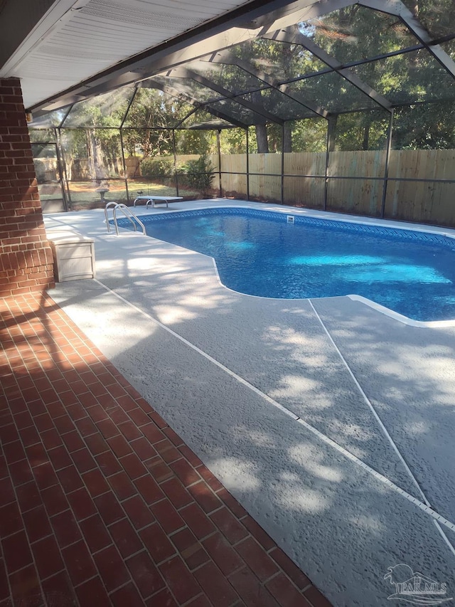 view of swimming pool with glass enclosure and a patio