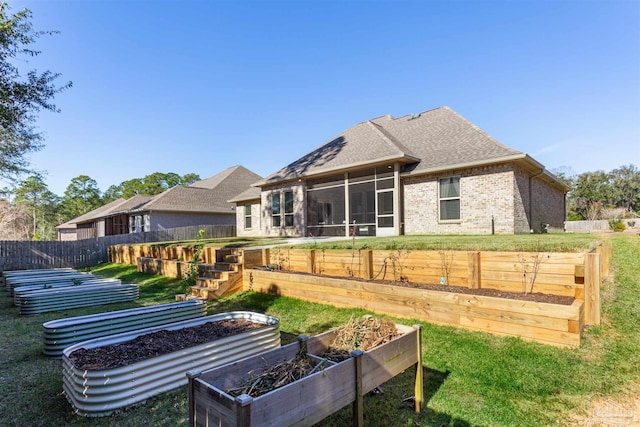 rear view of property featuring a yard and a sunroom