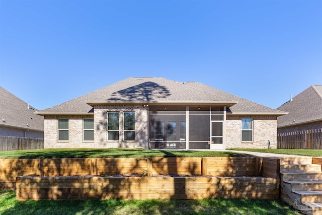 back of house with a sunroom and a yard