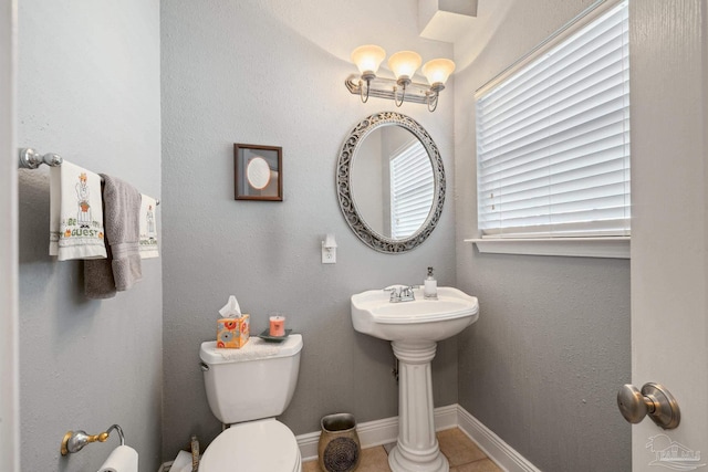 bathroom featuring sink, tile patterned floors, an inviting chandelier, and toilet