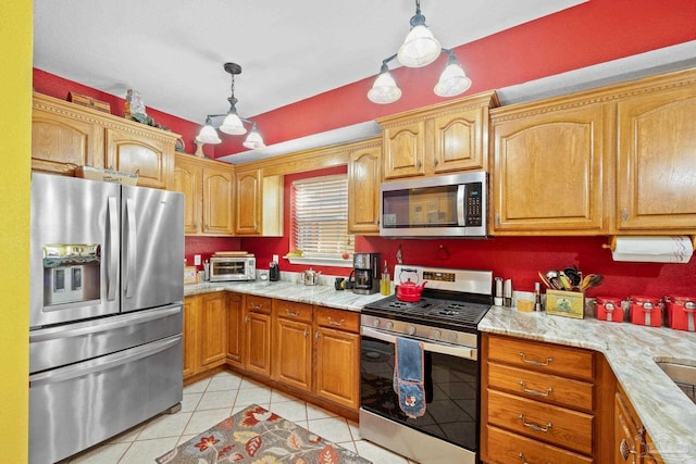 kitchen with appliances with stainless steel finishes, decorative light fixtures, light stone countertops, and light tile patterned floors