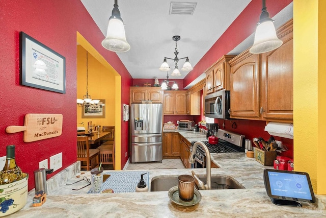 kitchen featuring decorative light fixtures, stainless steel appliances, and a chandelier