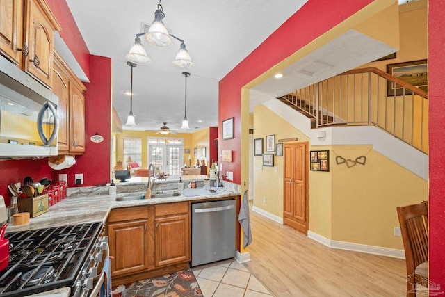 kitchen featuring sink, light hardwood / wood-style flooring, ceiling fan, stainless steel appliances, and decorative light fixtures