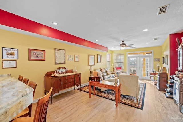 living room with light hardwood / wood-style floors, french doors, and ceiling fan