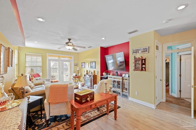 living room featuring light hardwood / wood-style flooring, ceiling fan, and french doors