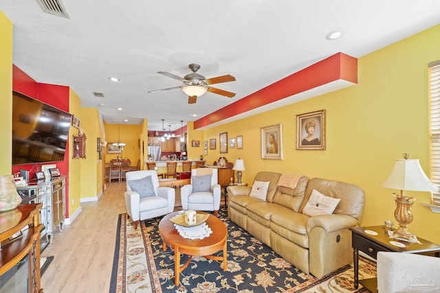 living room with ceiling fan and light hardwood / wood-style flooring