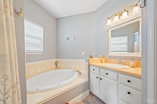 bathroom featuring vanity, a bathing tub, and a healthy amount of sunlight