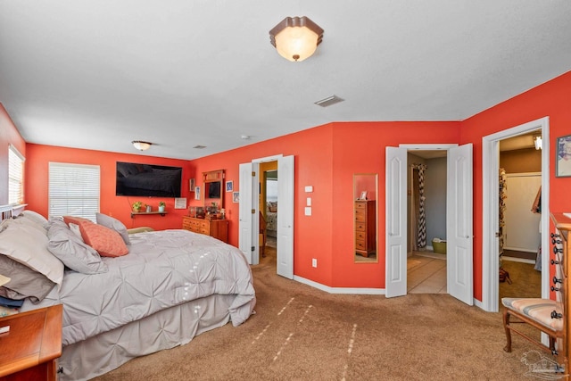 bedroom with a walk in closet and carpet flooring